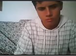 A boy in a sweatshirt masturbates on his couch