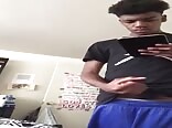 Black twink watching gay porn on his tablet 