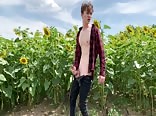 Boy wanks in field with sunflowers